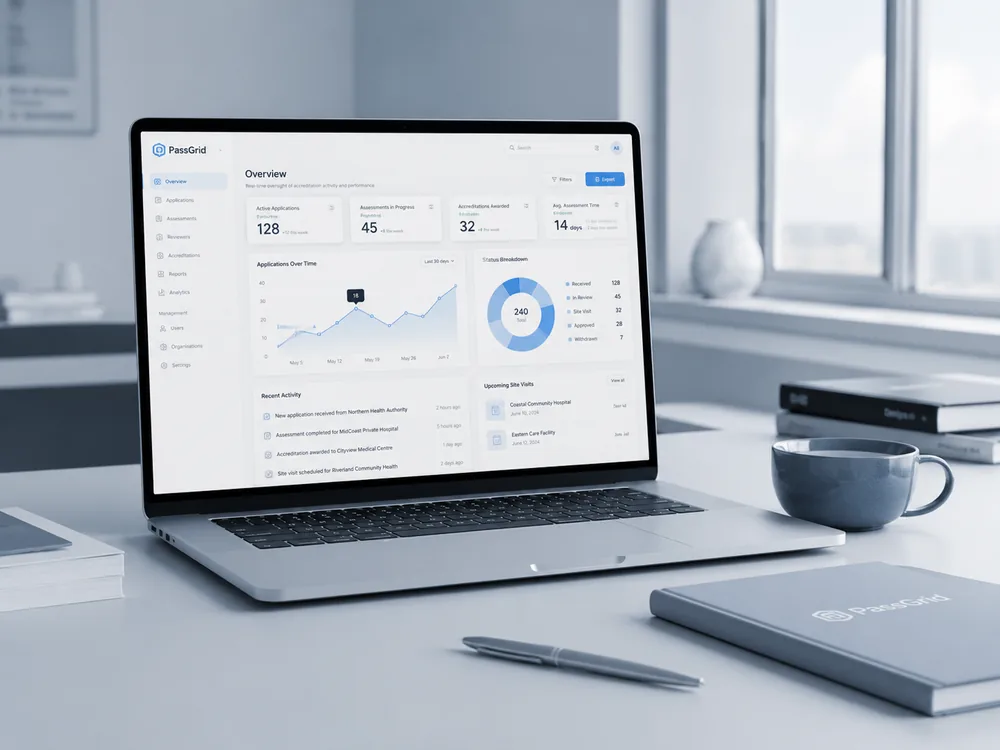 A laptop on a minimal desk showing the PassGrid accreditation dashboard